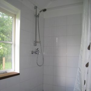 Badkamer met douche en wastafel op begane grond